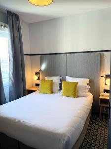 里昂里昂市奥德利生物园公寓式酒店的酒店客房配有一张带黄色枕头的大床