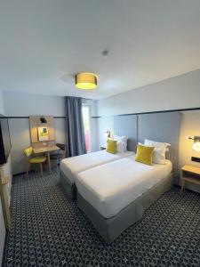 里昂里昂市奥德利生物园公寓式酒店的酒店客房配有两张床和一张书桌