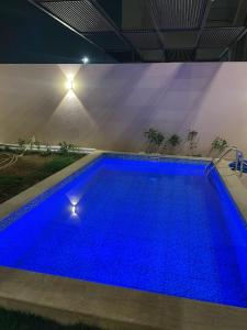 欧普尔شاليهات النرجس的夜间蓝色海水的大型游泳池