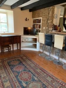 克朗梅尔Gurteen farm house的客厅配有桌椅和地毯。