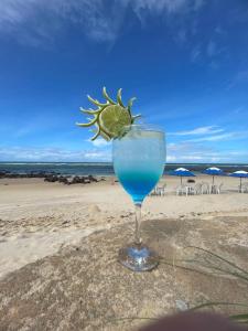 Barra de TabatingaPraia das Tartarugas的一杯蓝色饮料,在海滩上喝上石灰