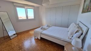加亚新城Apartamentos Jardim do Morro的白色卧室配有床和镜子