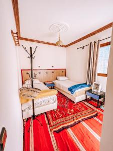 伊姆利尔Gite Panorama的红地毯间内的两张床