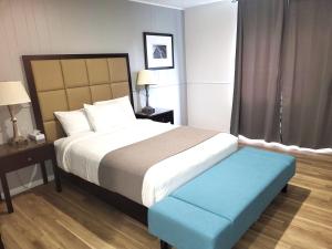 瓦勒多Hotel Sigma的一间卧室配有一张大床和蓝色的搁脚凳