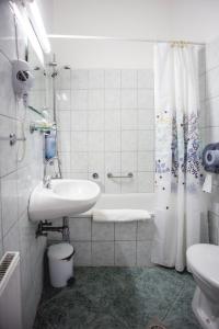 考波什堡卡波熙酒店的一间带水槽、浴缸和卫生间的浴室