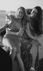 圣何塞7Pines Resort Ibiza, part of Destination by Hyatt的坐在沙发上拿着酒杯的两名妇女