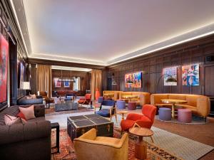 圣路易斯21c Museum Hotel St Louis的酒店大堂设有沙发、椅子和桌子。