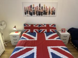 伦敦Modern, Large Independent Room with En-suite Bathroom in Private Owned Apartment的一间卧室配有一张带红色白色和蓝色毯子的床