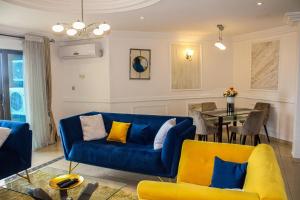 杜阿拉Residence Le Carat Bonapriso的客厅配有蓝色的沙发和桌子