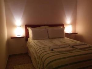 南蒙蒂阿莱格里Recanto dos Beija flores, Chalé Lantana c的一间卧室配有一张带两盏灯的床。
