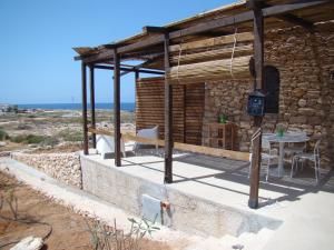 兰佩杜萨Holiday House Lampedusa的石头房子,配有桌子和桌子