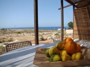 兰佩杜萨Holiday House Lampedusa的一张桌子上的一碗水果,享有海滩美景
