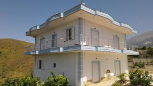 吉诺卡斯特Vila Antigonea的一座白色的建筑,上面设有一个阳台
