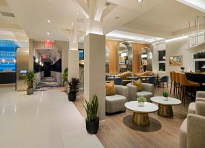法拉盛voco Fiorello - LaGuardia East, an IHG Hotel的大厅,设有沙发和桌子