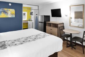 卡尔斯巴德Econo Lodge的酒店客房设有一张床铺、一张桌子和一间厨房。