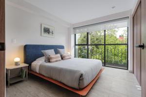 墨西哥城Choapan 28 - Lux Apartments in Condesa的一间卧室设有一张大床和一个大窗户