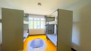 达累斯萨拉姆Gallivanters Hostel的一间设有双层床的房间和一扇带地毯的门