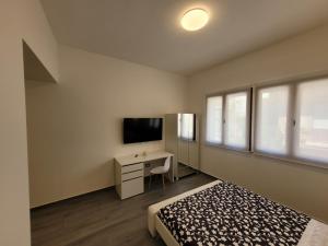 伊索拉戴里费米尼SP Rooms的一间卧室配有一张床、一张书桌和一台电视