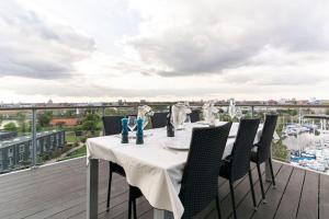 哥本哈根Penthouse with amazing views of Copenhagen!的阳台的桌子享有码头的景致
