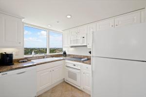 马可岛Marco Beach Ocean Suites的白色的厨房配有冰箱和窗户。