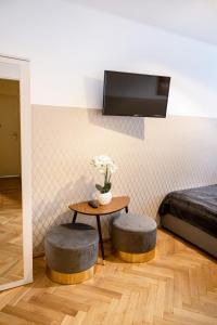 华沙ClickTheFlat Pereca City Centre Apart Rooms的一间设有一张桌子、两张凳子和一张床的房间