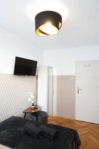 华沙ClickTheFlat Pereca City Centre Apart Rooms的一间卧室配有一张床、一盏灯和一张桌子