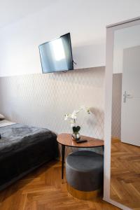 华沙ClickTheFlat Pereca City Centre Apart Rooms的卧室配有一张床和一张桌子,墙上配有电视