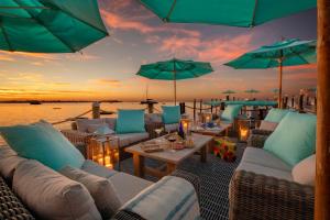 基拉戈Bungalows Key Largo - All Inclusive的一个带沙发和桌子及遮阳伞的庭院