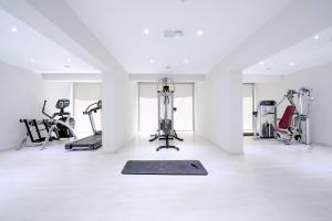 阿依纳帕河石酒店 的一间健身房,在白色的房间配有有氧器材