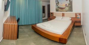 廷戈玛丽亚Hotel Rupa Rupa的一间卧室配有一张大床和蓝色窗帘