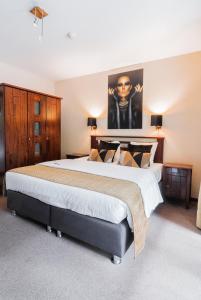 蒂伦豪特Turnhout City Hotel的一间大卧室,配有一张大床,墙上挂着一张海报