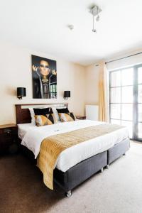 蒂伦豪特Turnhout City Hotel的卧室设有一张大床,卧室设有大窗户