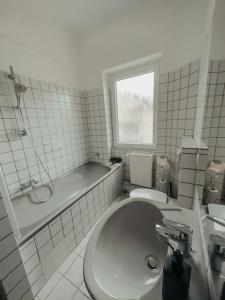科布伦茨Geräumige 3-Schlafzimmer-Wohnung in Koblenz nahe Uni的一间带水槽、浴缸和卫生间的浴室