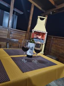 圣巴托洛梅CASA PABLITO的餐桌上放两杯葡萄酒,并设有一个壁炉