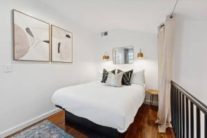 查尔斯顿Exclusive Open Loft in Downtown Charleston的卧室配有白色的床和黑白色枕头