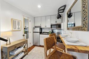 查尔斯顿Exclusive Open Loft in Downtown Charleston的厨房配有白色橱柜和木桌及椅子