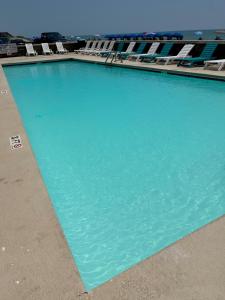 默特尔比奇Kingfisher Inn的一个带躺椅的大型蓝色海水游泳池