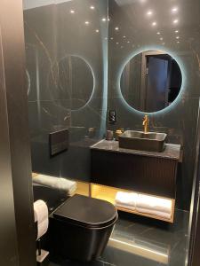 凯尔采Prestige Apartment Grabina的浴室设有黑色的卫生间和水槽。