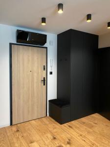 凯尔采Prestige Apartment Grabina的一间设有木门和黑橱柜的房间