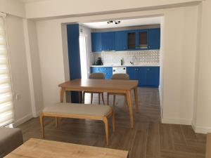 达拉曼No 444的厨房配有蓝色橱柜和木桌及椅子