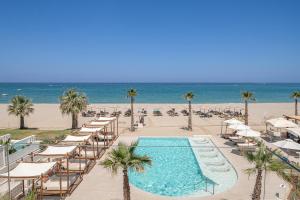 罗希姆诺艾佩里昂海滩酒店的一个带躺椅的游泳池和海滩