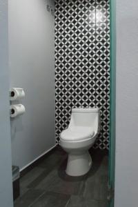 墨西哥城Hotel Flamencos的浴室设有卫生间,配有黑白墙纸。