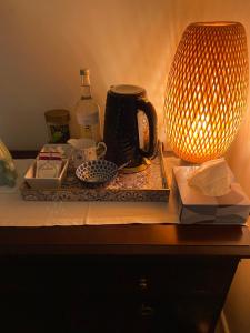 格拉斯顿伯里Starlight Cottage Room Only In Glastonbury的一张桌子,上面有台灯和盘子,还有咖啡壶
