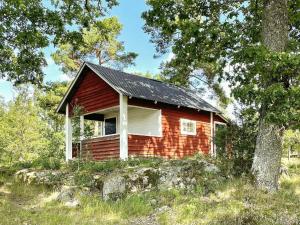 瓦尔德马什维克8 person holiday home in VALDEMARSVIK的森林中间的红色小屋