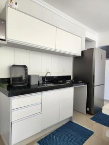 巴拉奈里奥-坎布里乌Apartamento Balneário Camboriú的白色的厨房配有水槽和冰箱