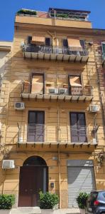 巴勒莫Da Mari e Paolo的黄色的建筑,旁边设有阳台