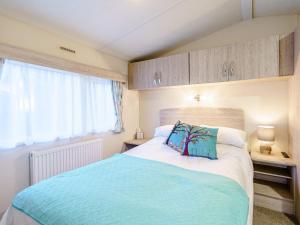 DollarThe Paddocks - Uk7112的一间卧室设有一张大床和一个窗户。