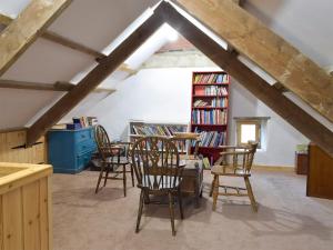 新码头日瓦乡村别墅的一间带椅子和桌子的房间以及书架