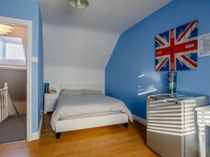 拉姆斯盖特Relax In Ramsgate的一间卧室设有一张床和蓝色的墙壁