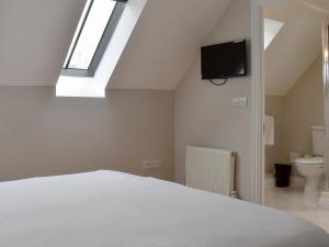 马托克Hollies Cottage 16 - Uck4539的卧室配有白色的床和天窗